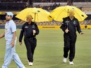 Umpires Steve Davis and Rudi Koertzen walk out to the middle with umbrellas, India v Sri Lanka, CB Series, February 5, 2008