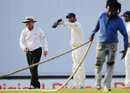 MS Dhoni points to umpire Ian Gould to some wet spots in the outfield after a rain interruption, West Indies v India, 2nd Test, Bridgetown, 5th day, July 2, 2011 