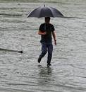 A man walks on water-logged covers, Sri Lanka v New Zealand, 1st ODI, Pallekele, November 1, 2012