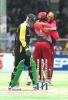 Pakistan captain Moin Khan (L) turns and walks back to the pavilion 19 April, 2000 after being bowled by West Indies captain Jimmy Adams as wicketkeeper Ridley Jacobs (backing) hugs his captain in celebration at the first Cable & Wireless One Day International Final at Kensington Oval, Barbados.