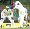 Marlon Samuels hits a ball to the boundary as Sri Lanka fielder Mahela Jayawardene looks on