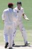 Australian test cricket captain Adam Gilchrist (R) shakes hands with West Indies captain Jimmy Adams (red cap), after Australia's five wicket win in the third test at the Adelaide Oval, 19 December 2000. The win is the first for stand in captain Gilchrist who replaced the injured Steve Waugh for this match, and extends Australia's world record unbeaten run to 13.