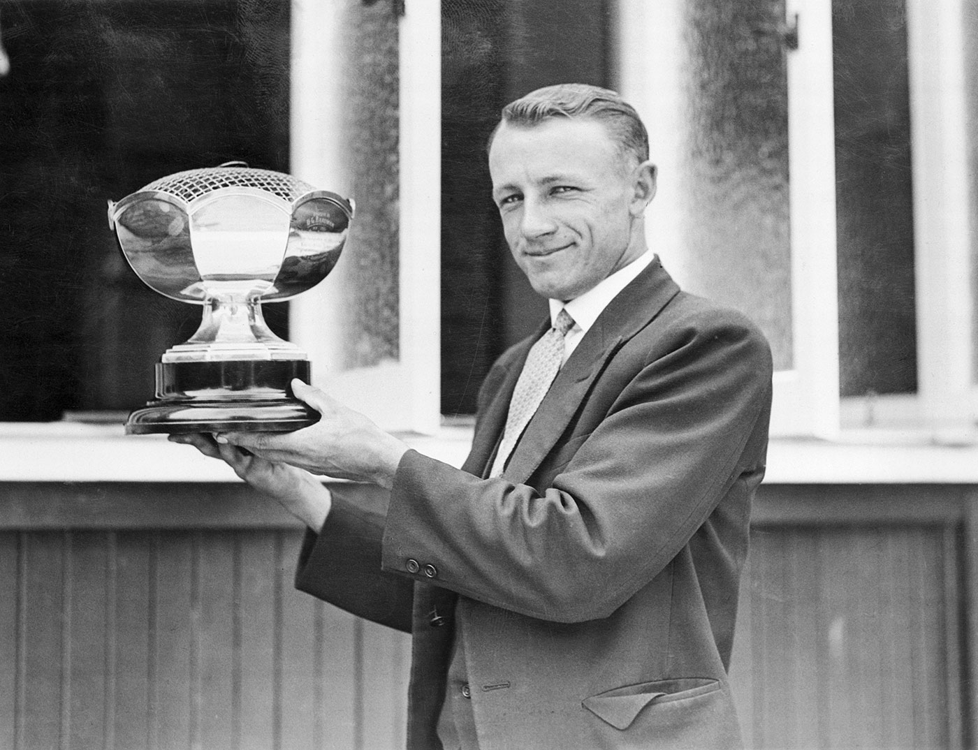 Donald Bradman holds up a trophy