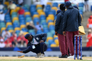 A member of groundstaff attempts to dry a wet spot on the pitch with a sponge, England vs Scotland, T20 World Cup, Barbados, June 4, 2024